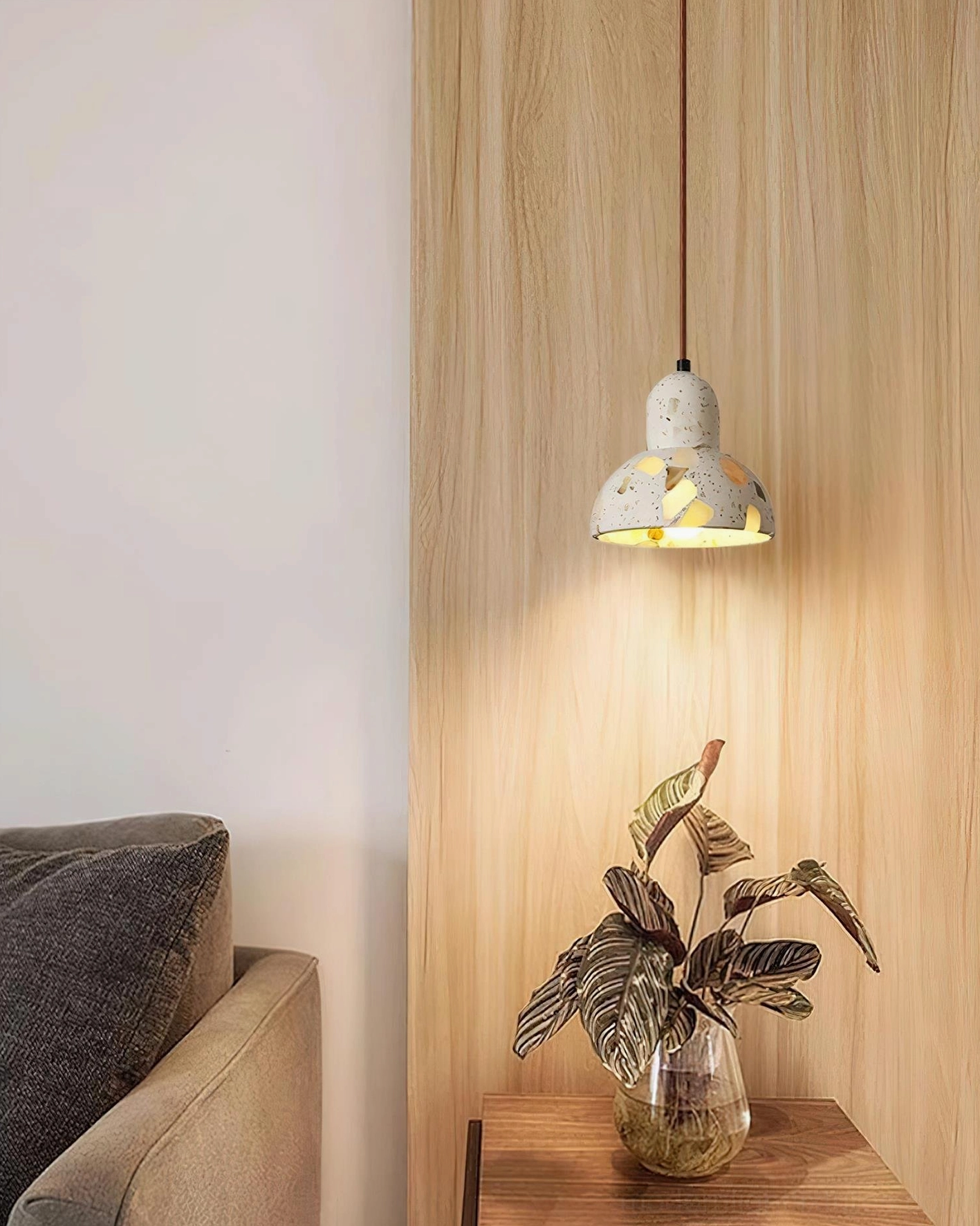 Single terrazzo pendant light fixture in living room corner providing accent ambient lighting