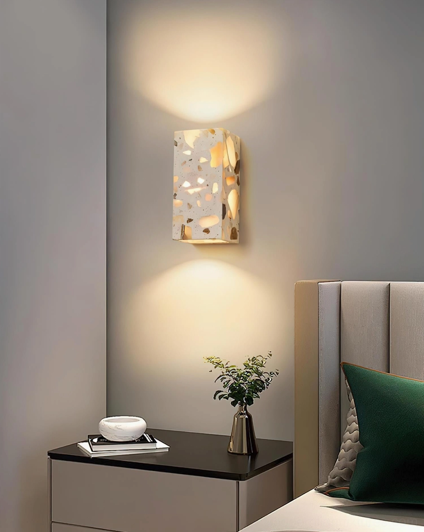 Terrazzo wall sconce in modern master bedroom on bedside wall creating warm atmospheric lighting for contemporary minimalist interior design