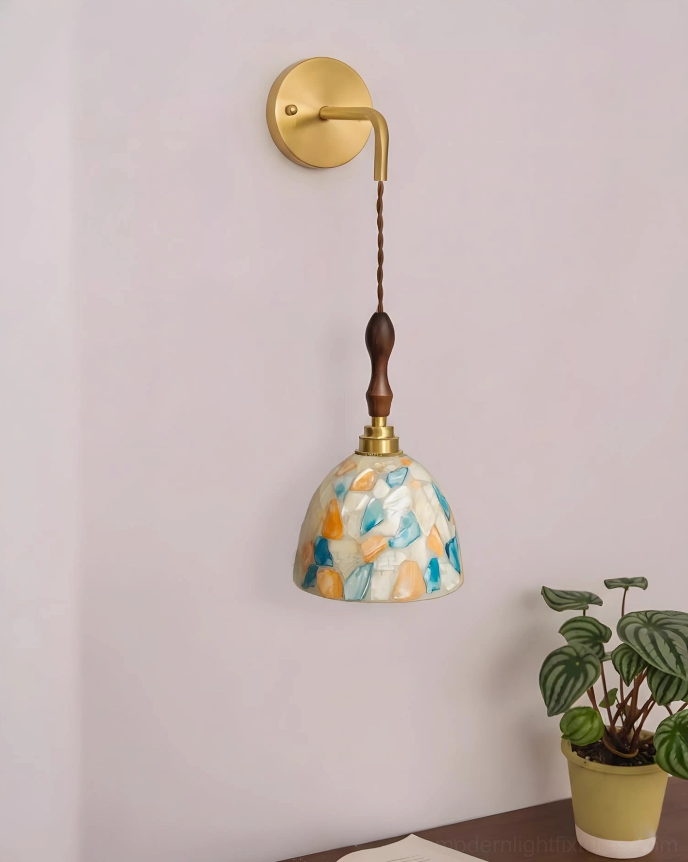 Tessaro wall sconce with marbled glass shade detail, minimalist aesthetic with potted plant