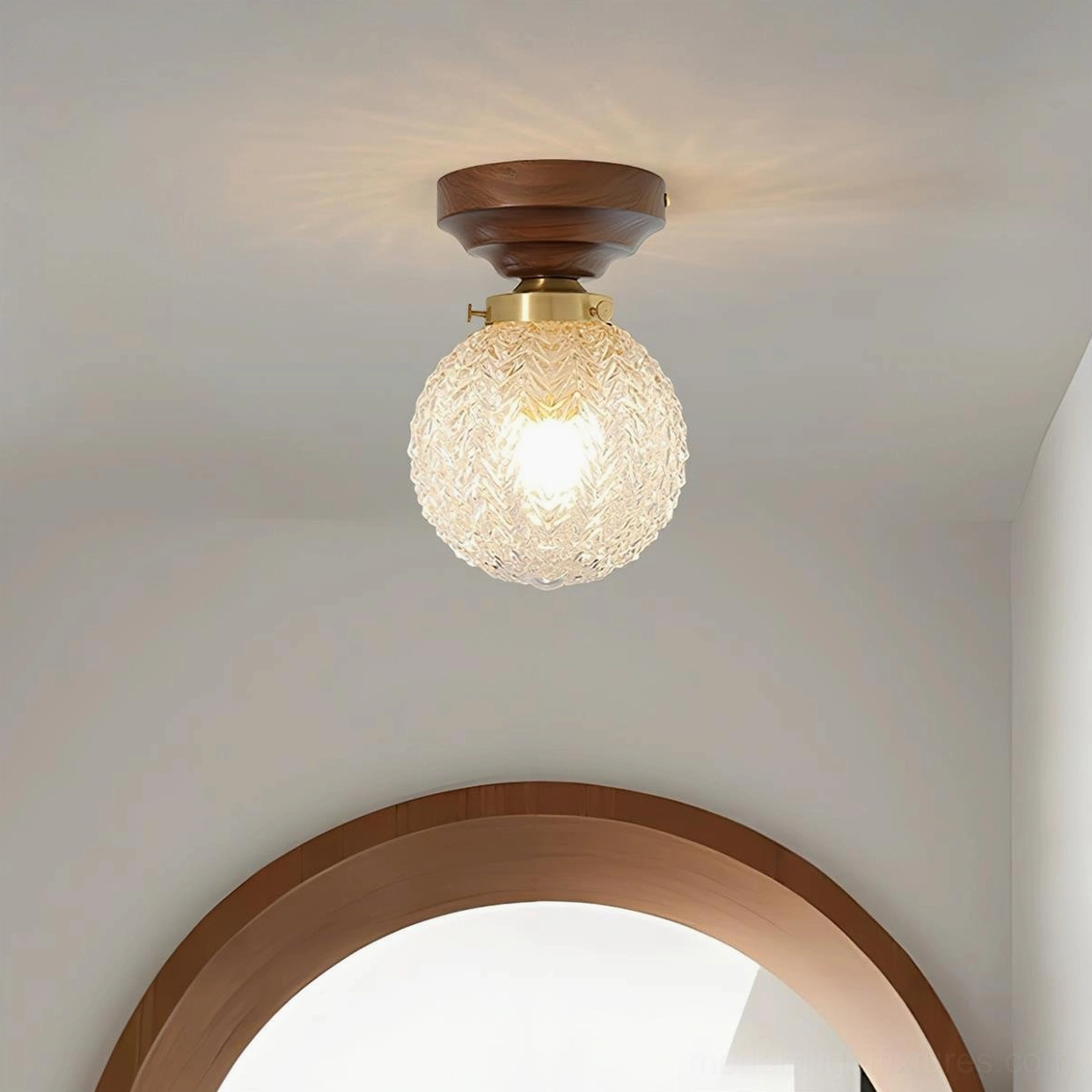 Vintage modern flush mount ceiling light installed in residential hallway, warm glowing glass globe with dark wood base