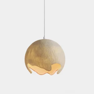 Moon crater pendant light with textured resin sphere shade featuring irregular bottom cutout, shown in studio with warm ambient lighting
