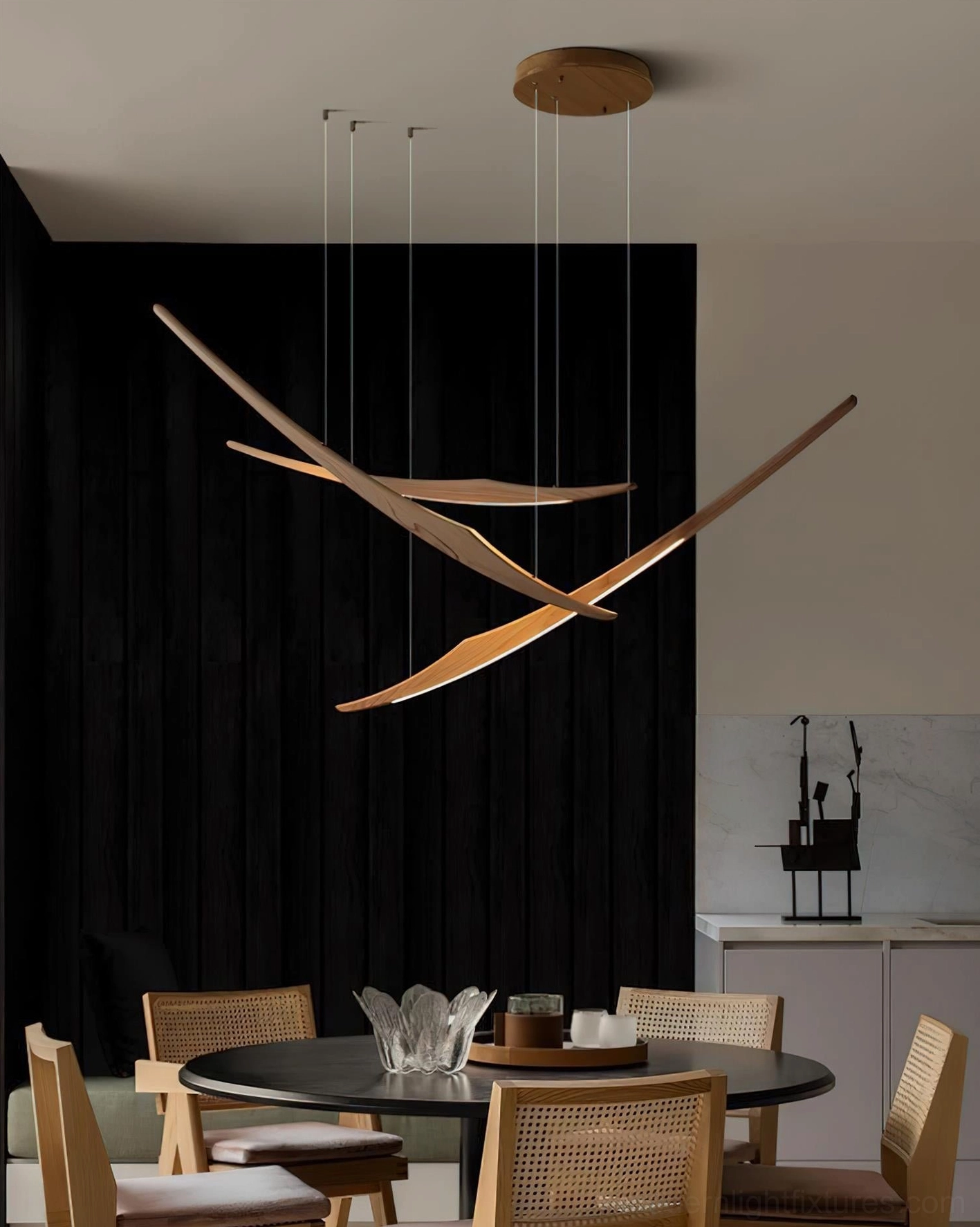 Triple arc wooden pendant chandelier installed above round dining table in modern dining room