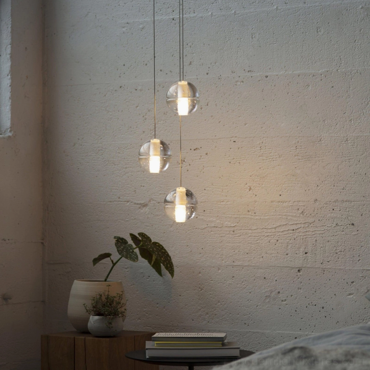 Three-head crystal pendant light in bedroom corner with soft minimalist design