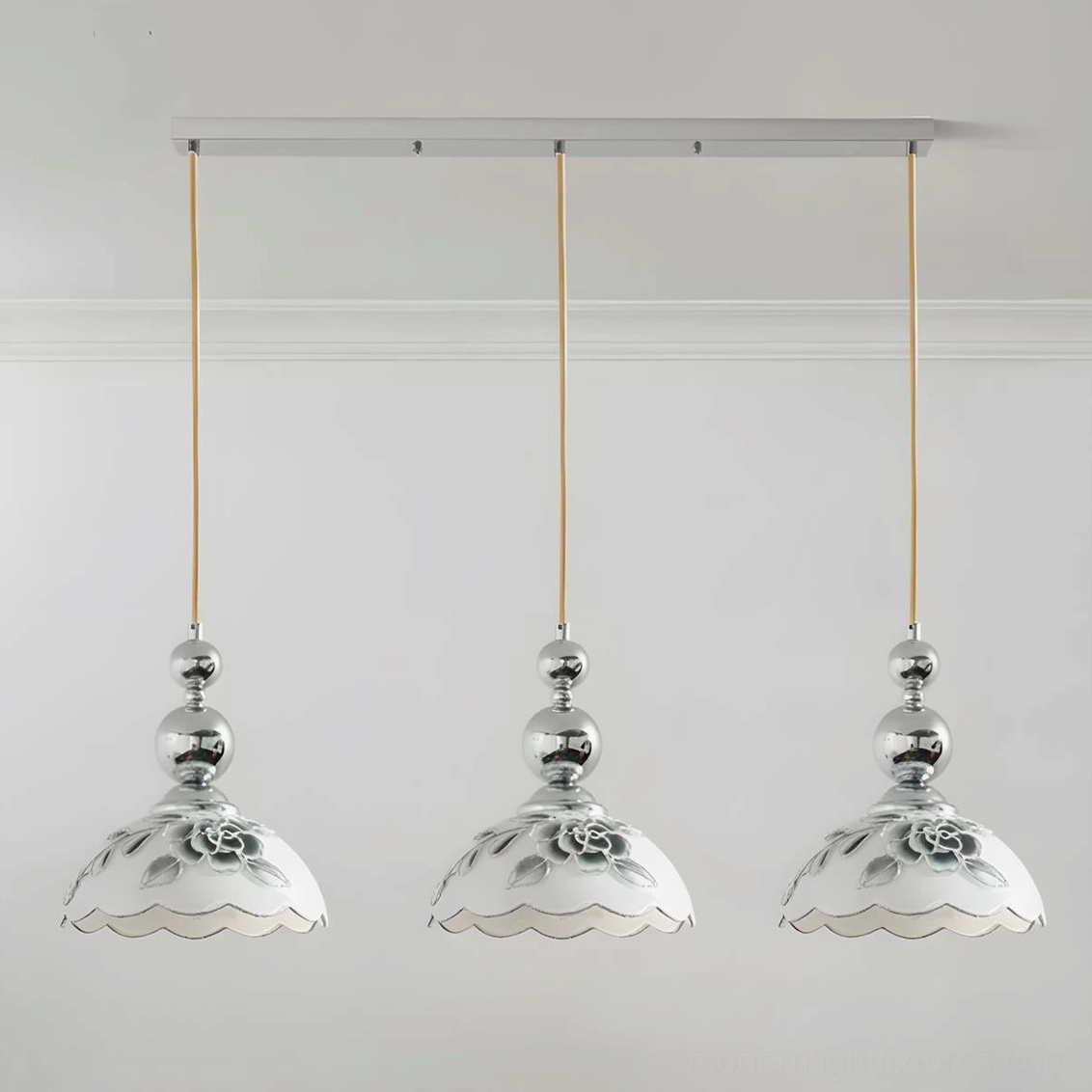 Front view of 3-head linear pendant light with scalloped floral glass shades and chrome hardware