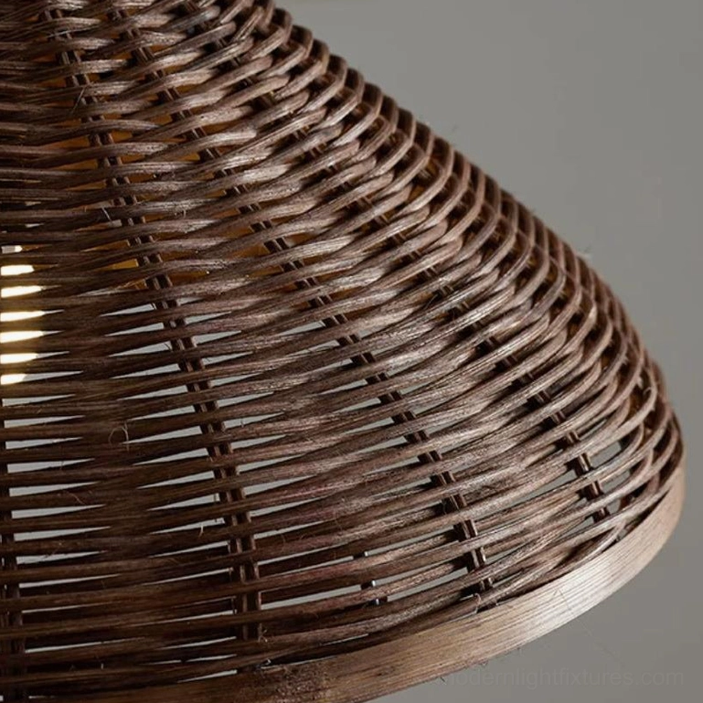 Three-light linear rattan pendant cluster on black metal bar, kitchen island installation overhead view