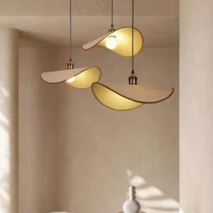 Set of three matching handcrafted pendant lights with warm fabric shades and brass-toned holders in overhead residential view