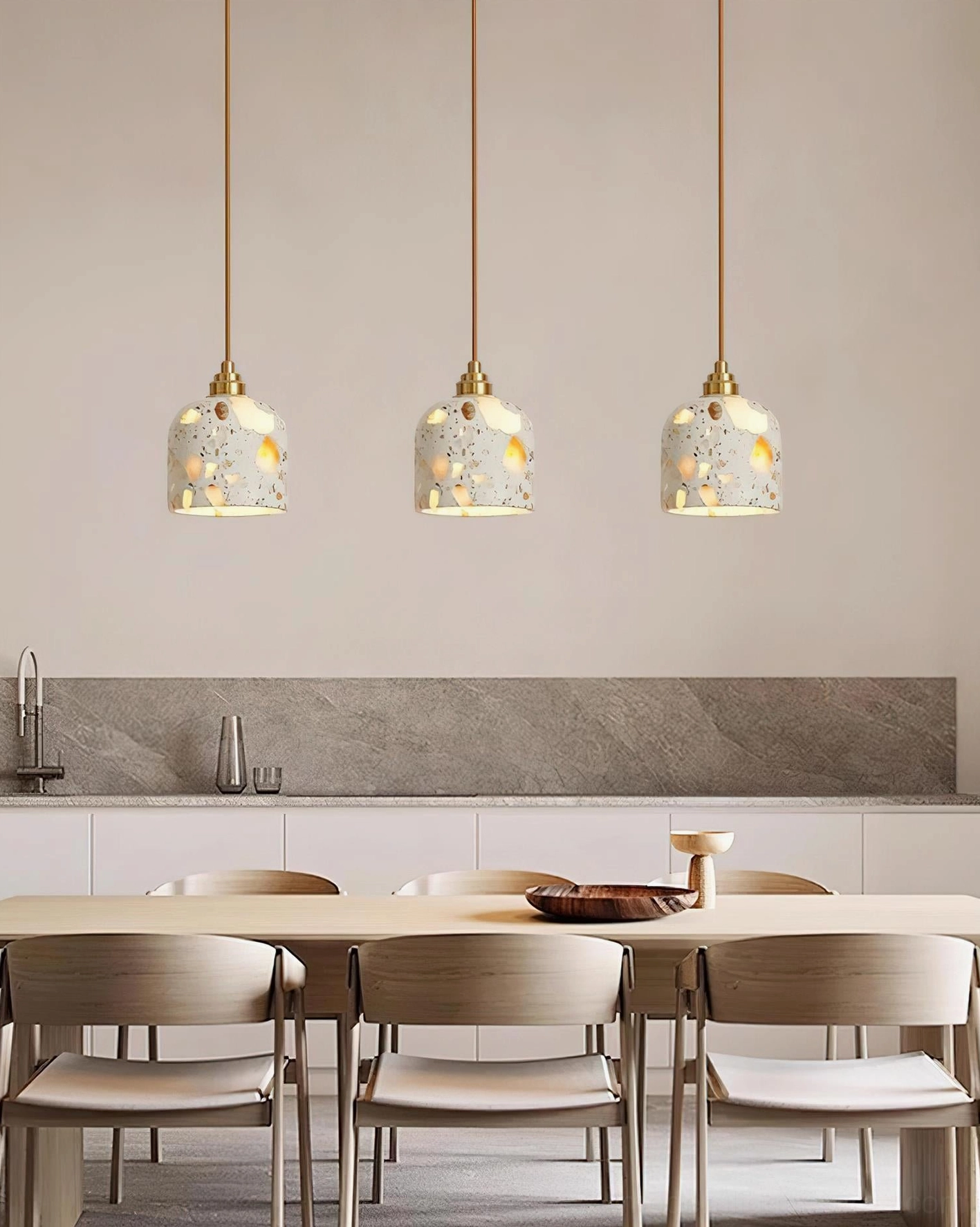 Three terrazzo pendant lights in contemporary open-plan kitchen and dining area above wooden table