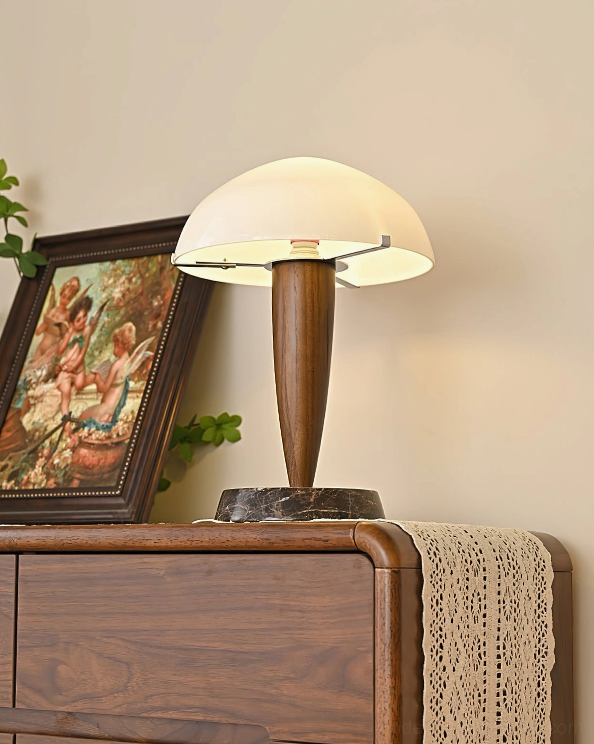 Tibby table lamp three-quarter view in vintage-inspired interior with framed painting and green foliage - home staging scene