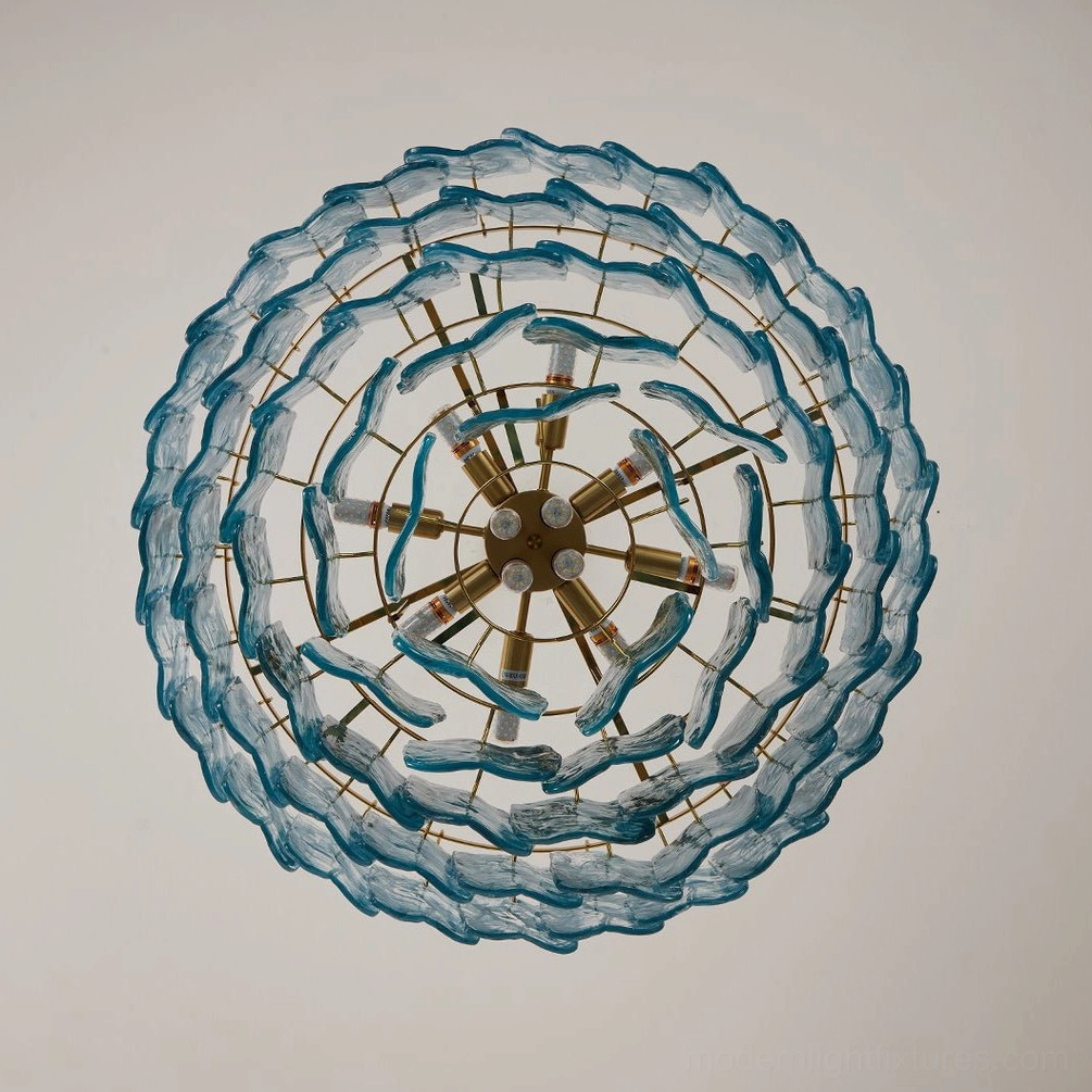 Modern tiered glass chandelier detail view, showing wavy textured glass panels and brass metal framework architectural design