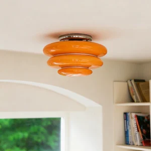 Tiered orange glass ceiling light installed in residential interior with archway and bookshelf, upward viewing angle