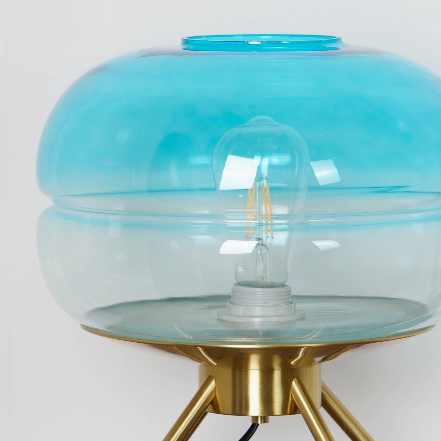 Tiered glass table lamp with brass base demonstrating scale and proportions in room setting