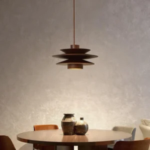 Tiered wood pendant light hanging above modern dining table in residential interior, warm ambient lighting through layered disc construction