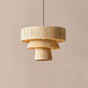 Overhead view of tiered natural raffia hanging pendant lamp with pleated woven shade against warm interior wall backdrop