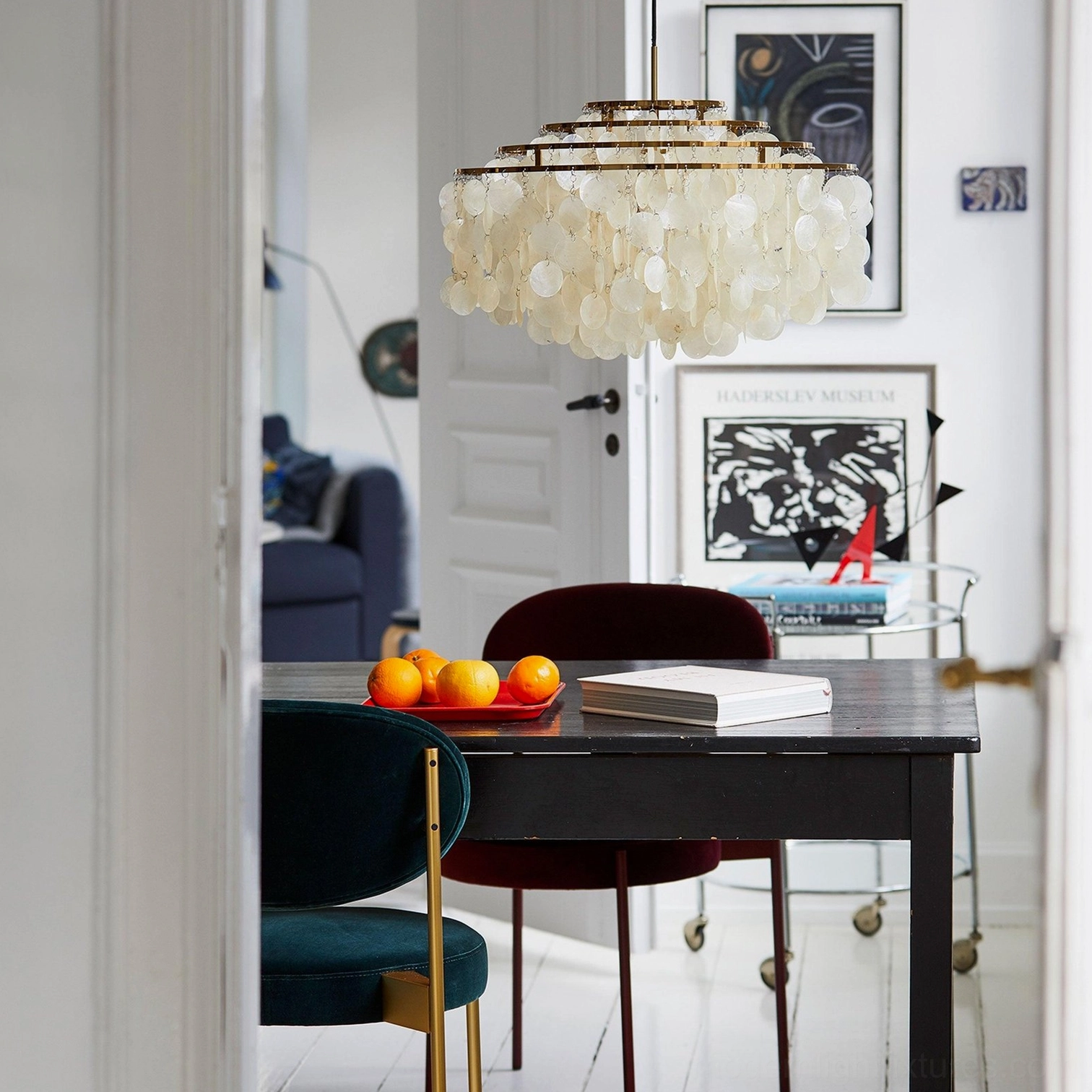 Tiered shell pendant chandelier in bedroom setting, soft warm light diffusion