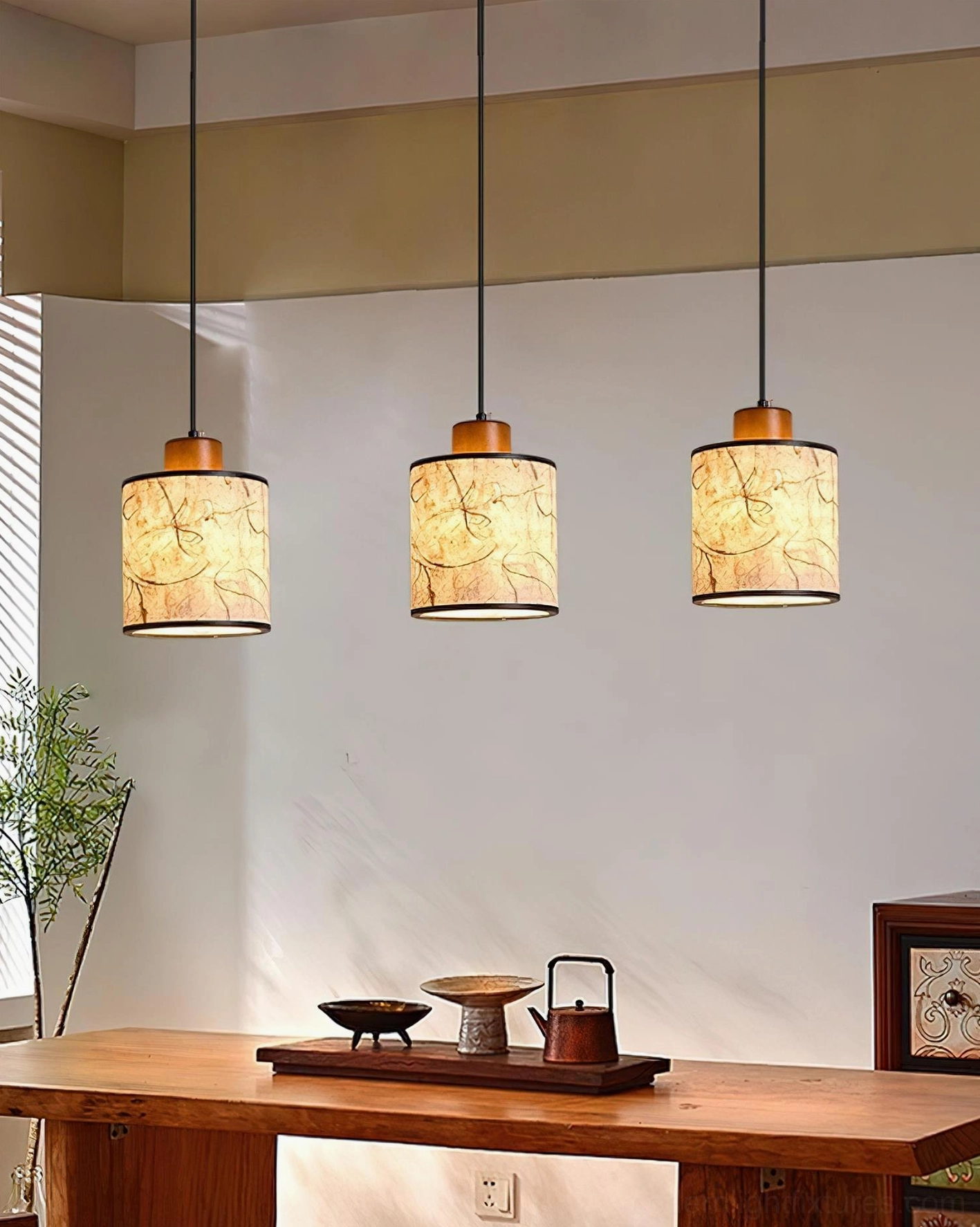 Three-head Tierra pendant lamp cluster in traditional tea room setting above wooden dining table with warm ambient lighting
