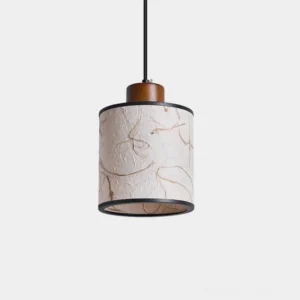 Tierra handmade pendant light with textured rice paper cylinder shade, black metal frame, and wooden accent cap in studio setting