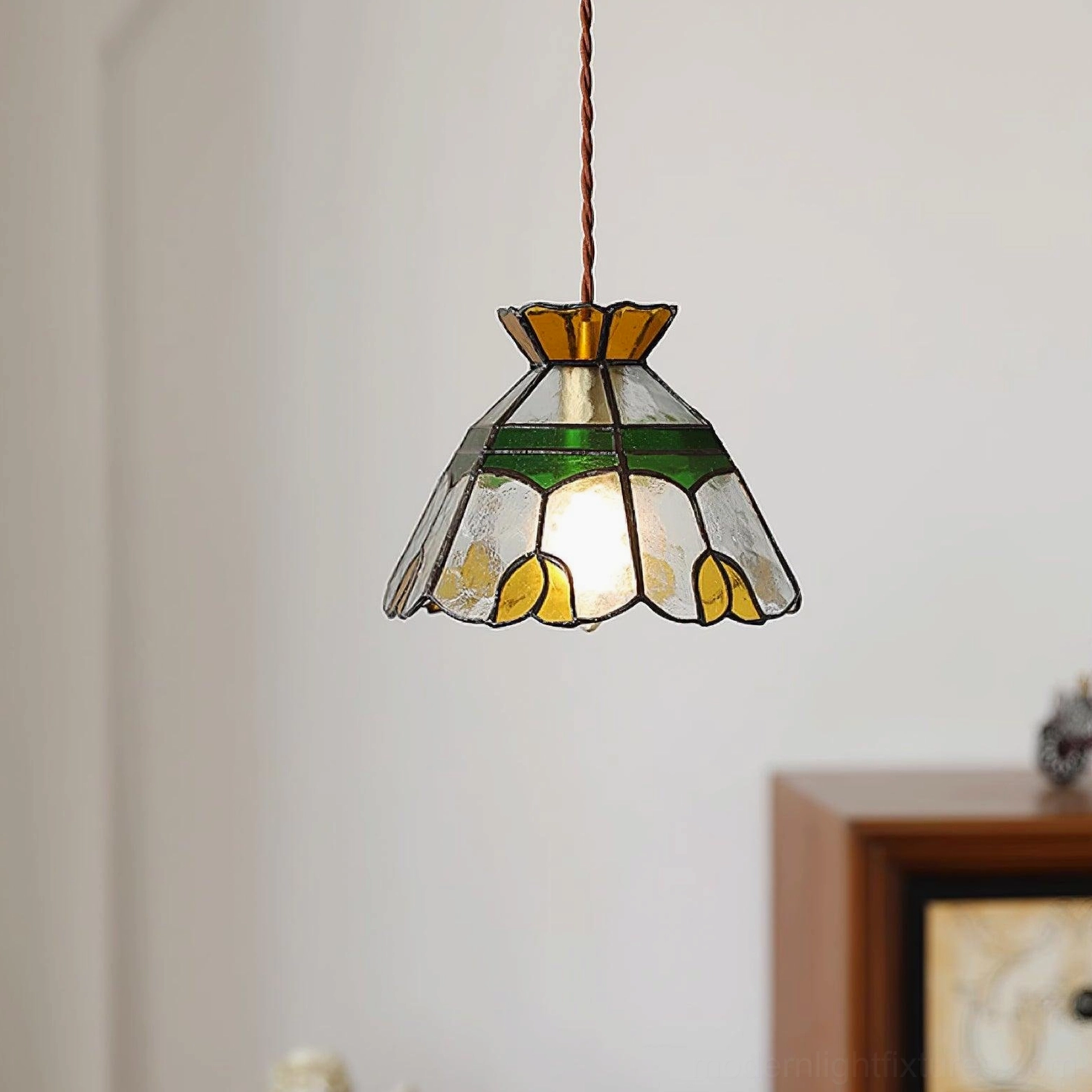 Hand-crafted Tiffany stained glass pendant lamp casting beautiful colored light into interior space, vintage floral botanical design