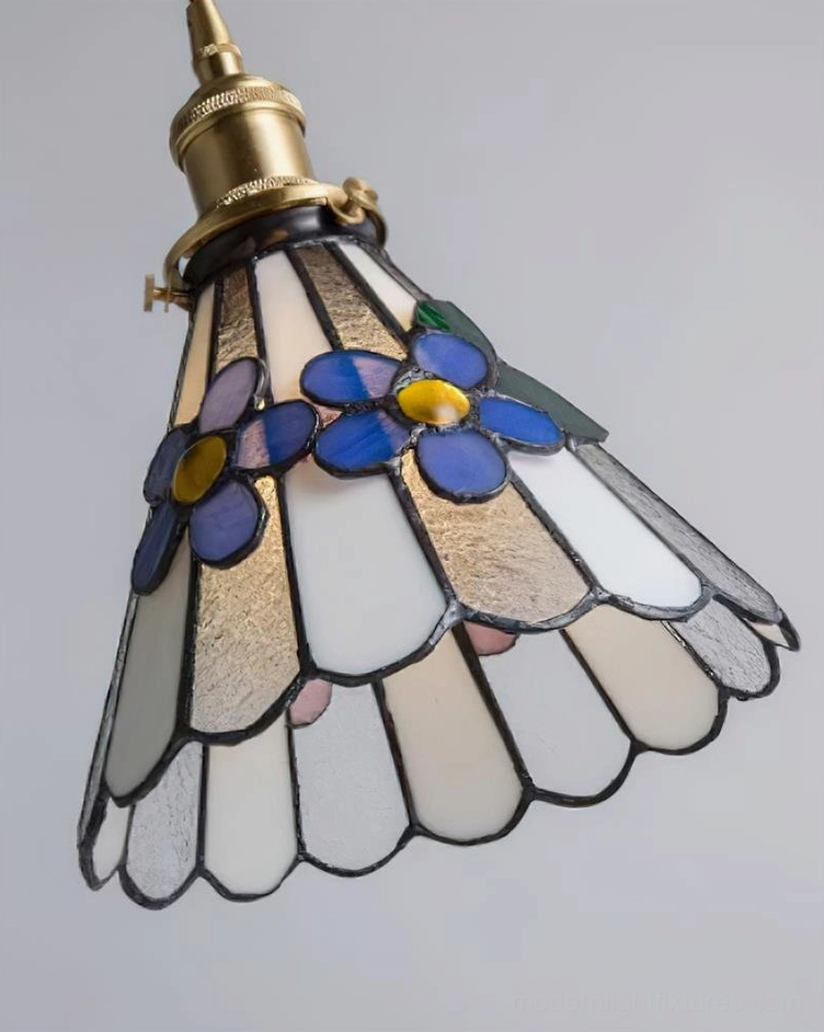Tiffany style pendant lamp with ornate stained glass shade and adjustable brass cord in room setting