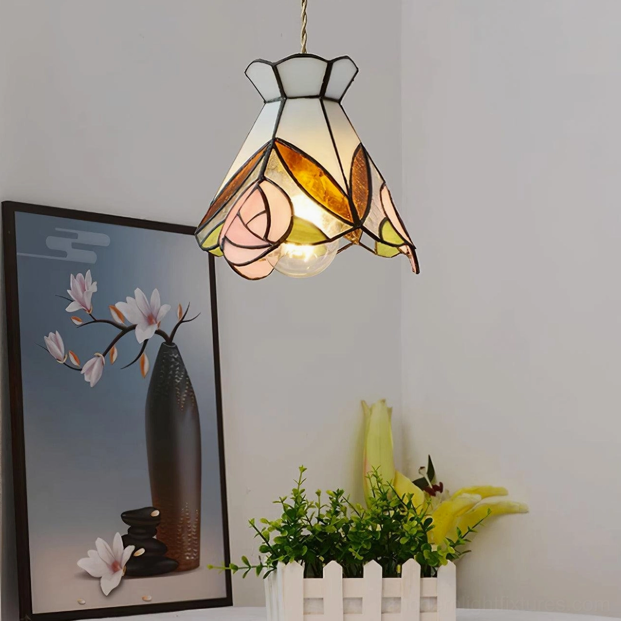 Tiffany rose pendant light in residential corner setting with exposed bulb visible and floral wall art pairing