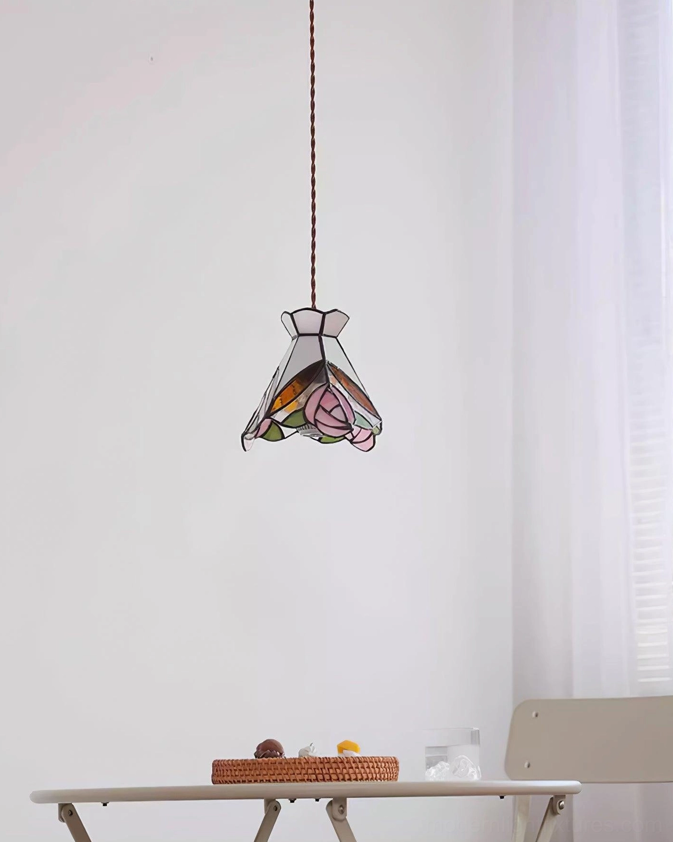 Vintage Tiffany rose pendant lamp with pink stained glass shade and brass hardware in display setting