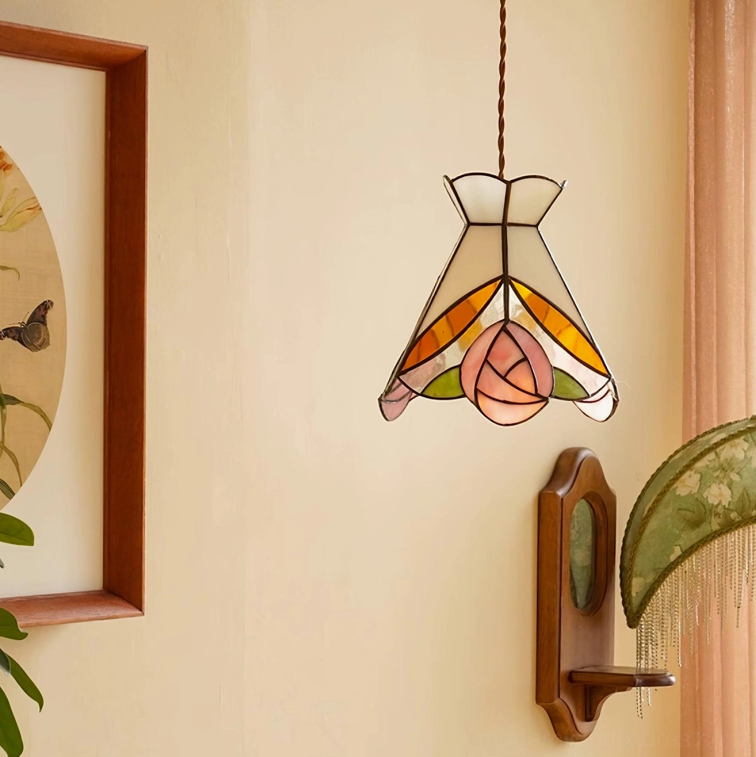 Detailed front view of Tiffany rose and leaf motifs in stained glass pendant shade with brass accents