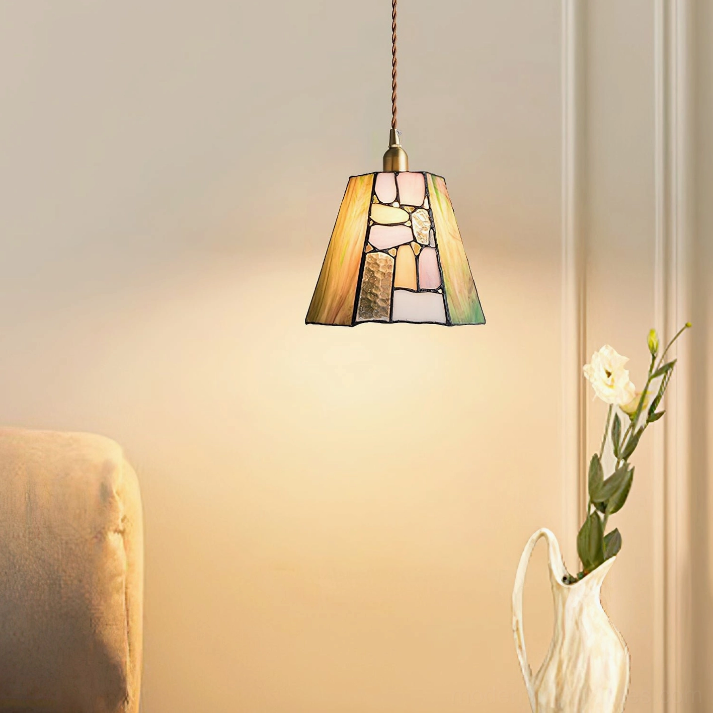 Tiffany style stained glass pendant light with amber-green glass shade in living room setting with floral decor