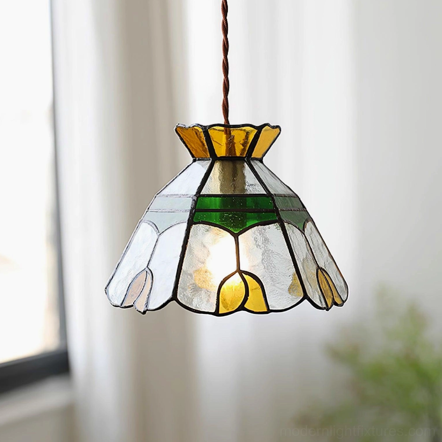 Tiffany stained glass pendant light fixture with hand-crafted colored glass shade, brass hardware, and adjustable brown cord