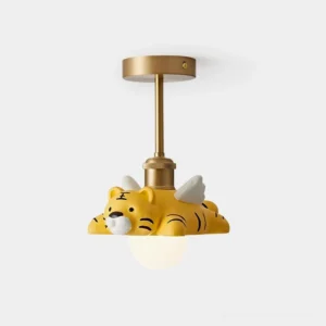 Tiger ceiling light fixture with brass metal wings and yellow resin animal figure perched on frosted glass orb, studio front close-up view