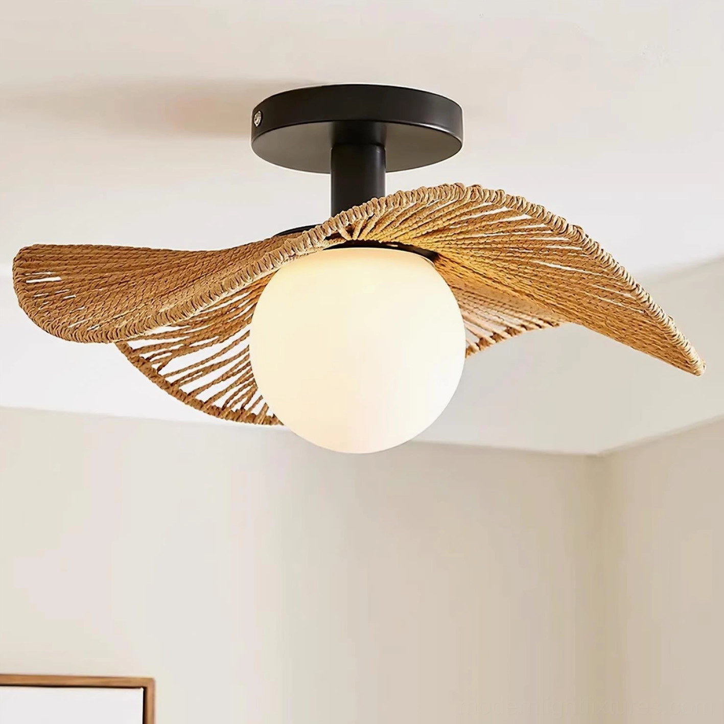 Tilda rattan ceiling light fixture with frosted white globe diffuser, right-side view against beige wall with picture frame