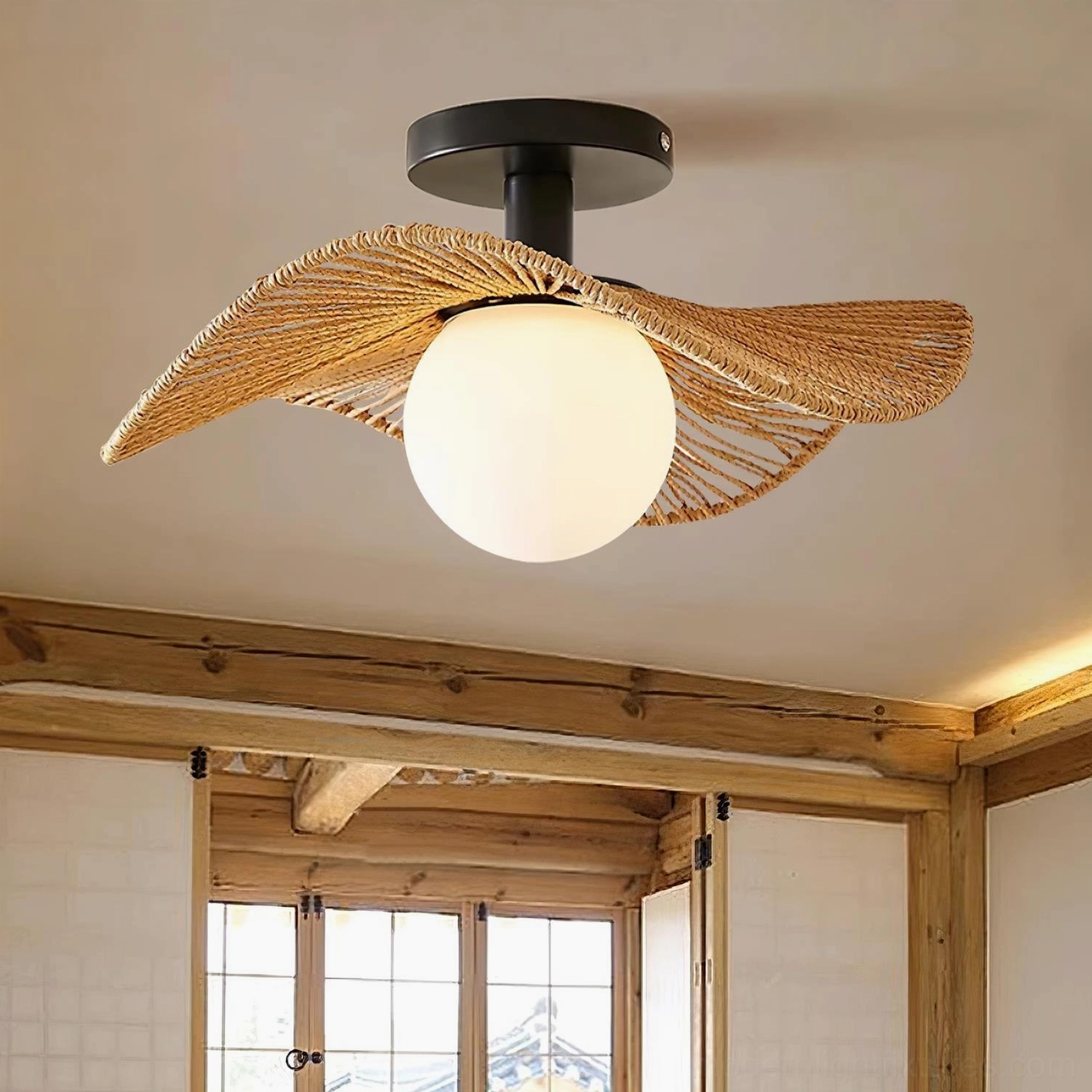 Tilda rattan ceiling light with natural brown woven shade mounted in traditional wooden beam room with French windows, overhead view