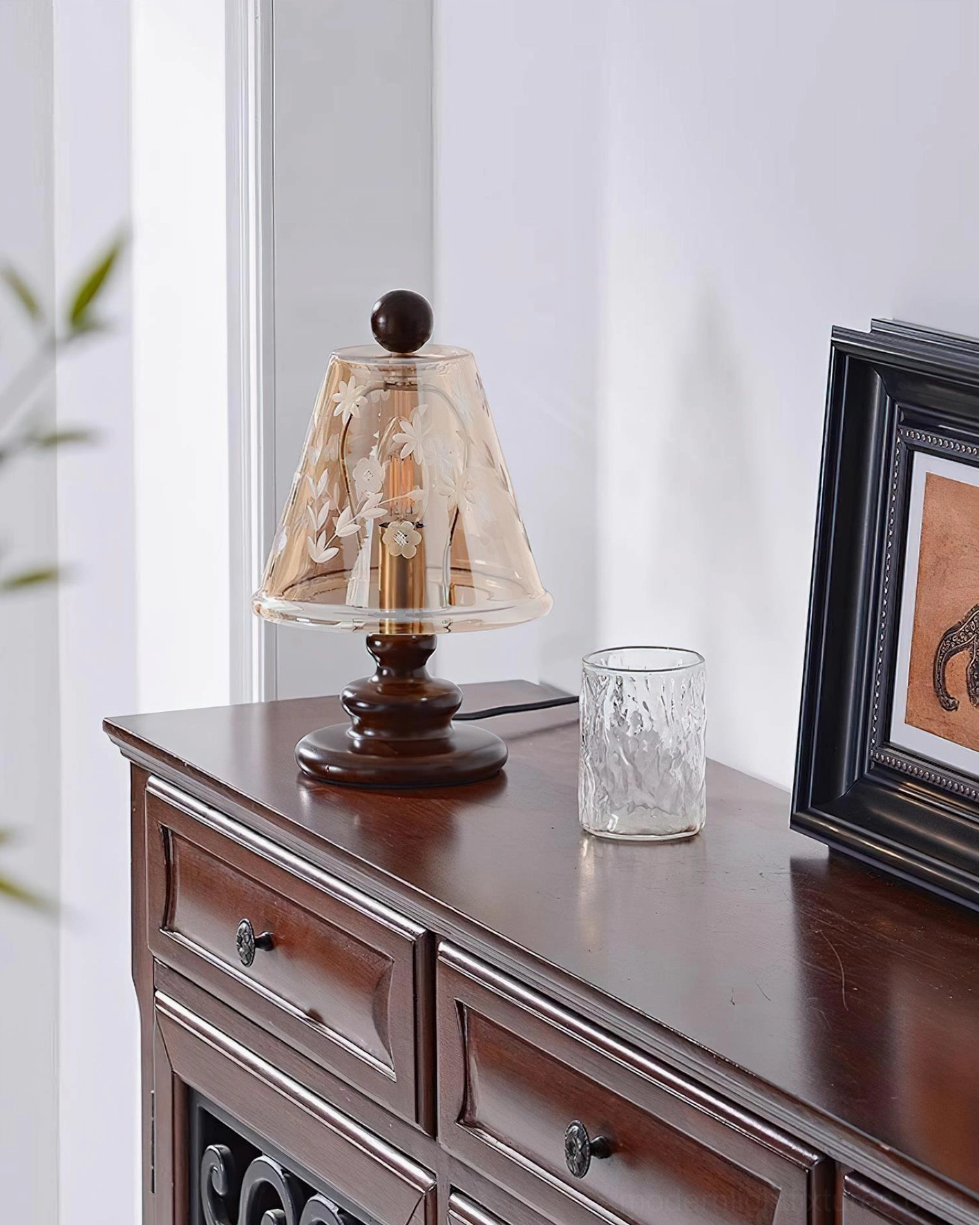 Tilda table lamp side profile with clear amber glass shade and dark brown rounded wooden base in living room