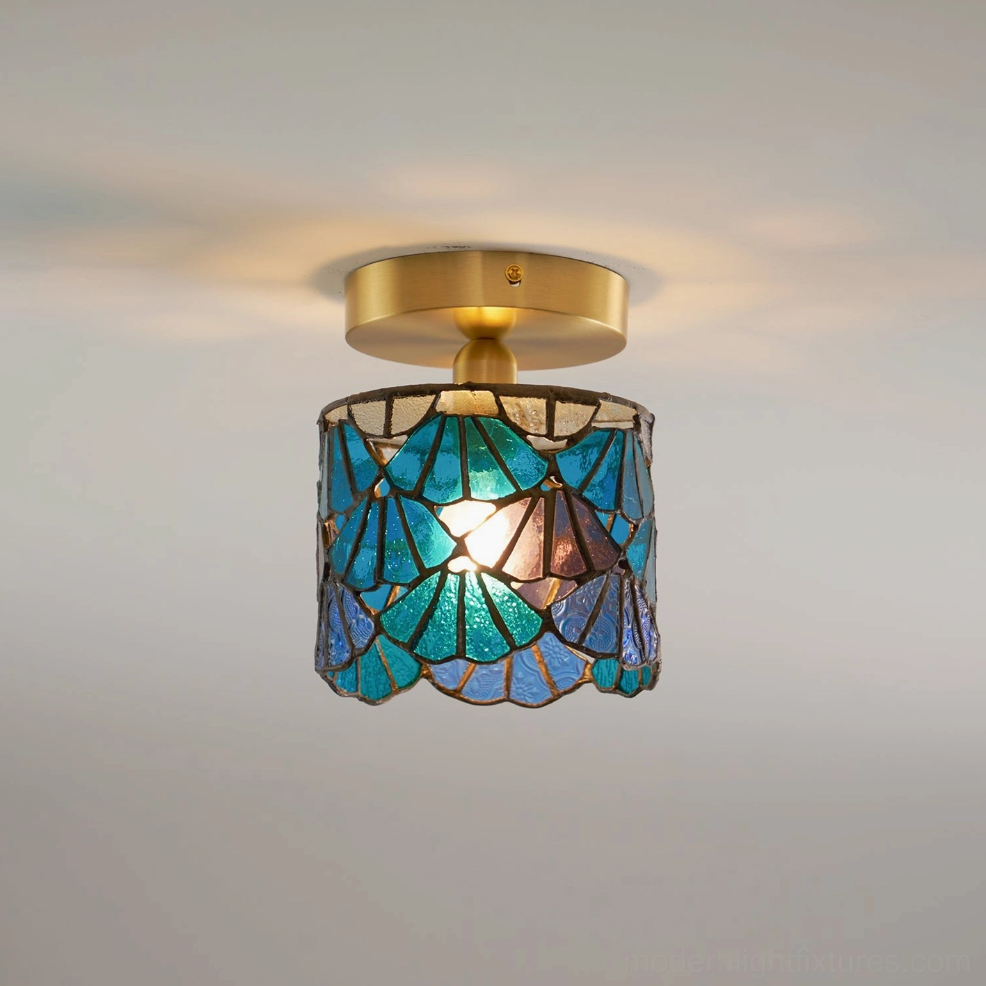 Semi-flush Tiffany ceiling light showing three-quarter view of blue stained glass shade with lead-line pattern and brass mounting