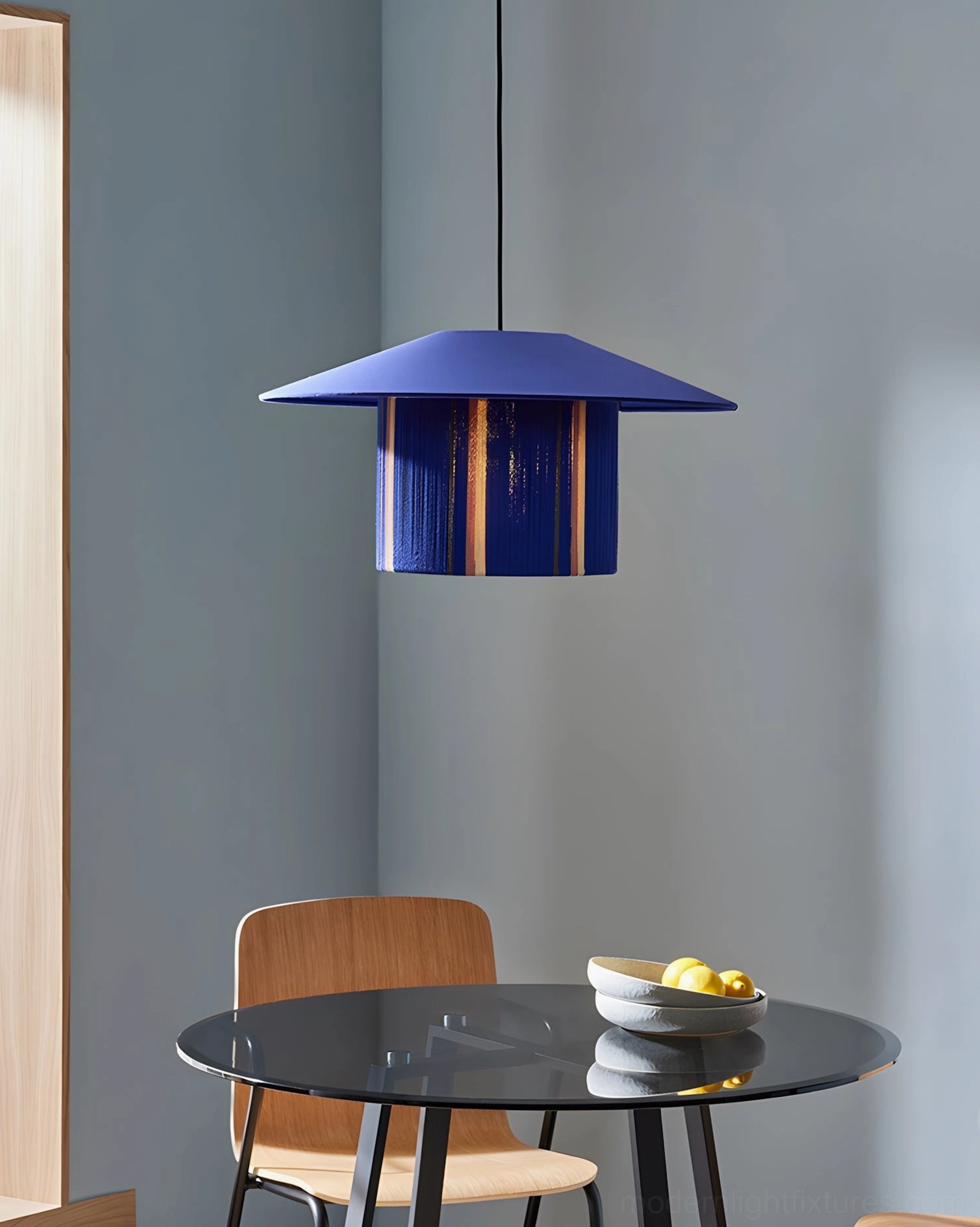 Tivaro blue rope pendant lamp in modern dining nook, navy accent wall, small apartment dining space with black glass table