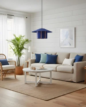 Tivaro pendant light in coastal living room, indigo striped shade above seating area with white shiplap walls and blue accent pillows