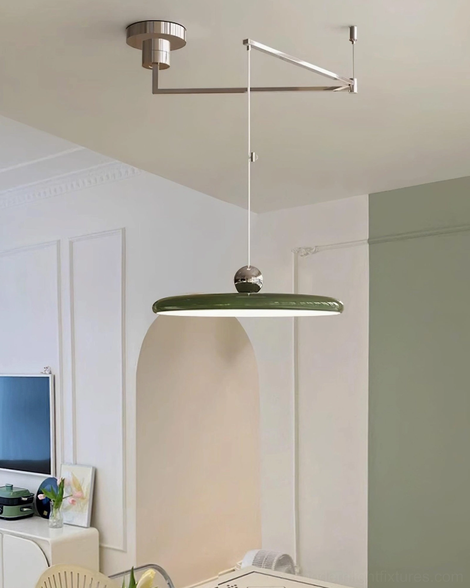 Olive green disc pendant lamp suspended in French retro dining room with warm ambient lighting
