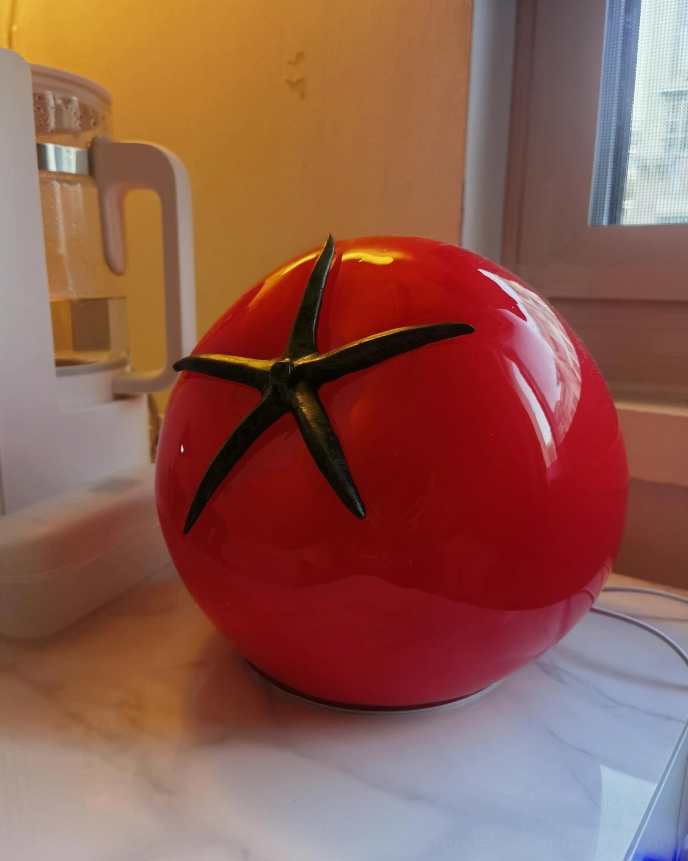 Tomato table lamp three-quarter side view on marble windowsill countertop with coffee machine styling