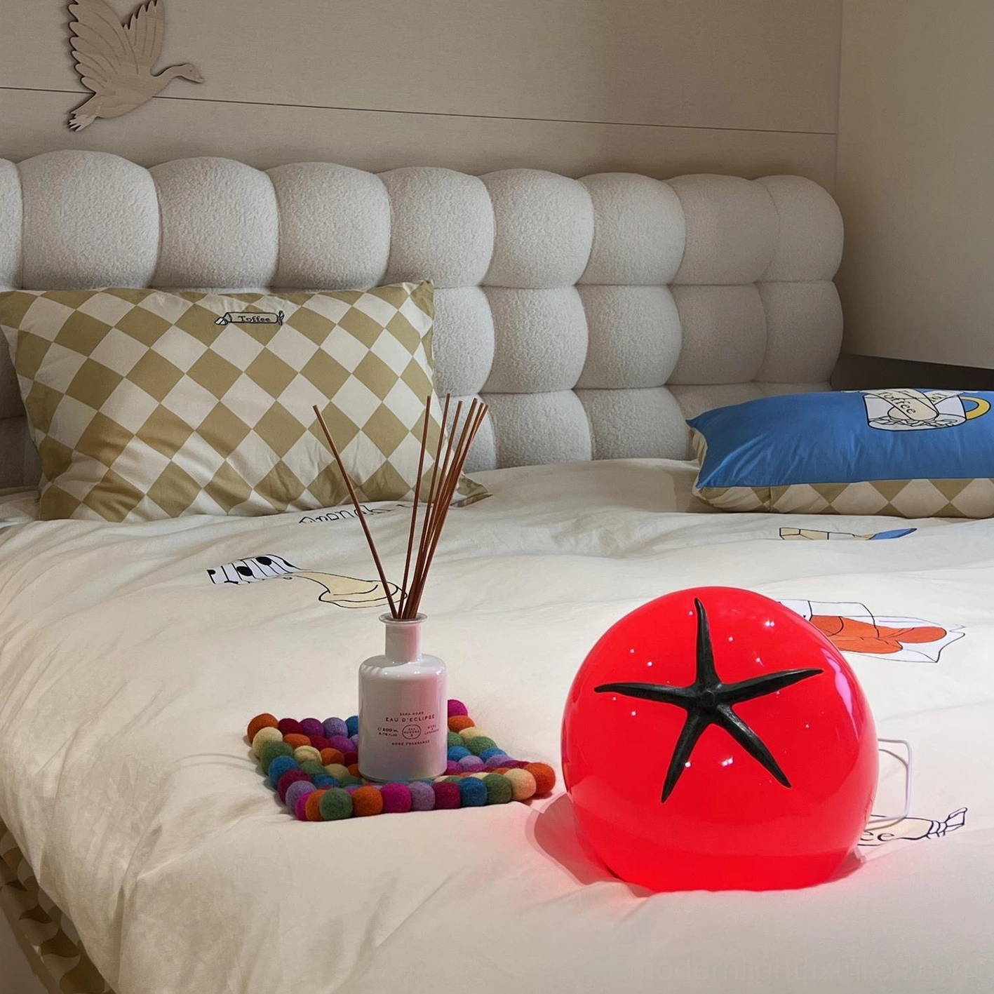 Tomato resin table lamp top-down view on bed surface, playful home accent décor piece