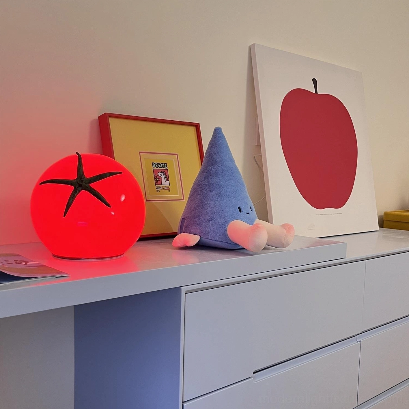 Tomato table lamp on bedroom vanity desk paired with framed artworks and decorative gnome accent