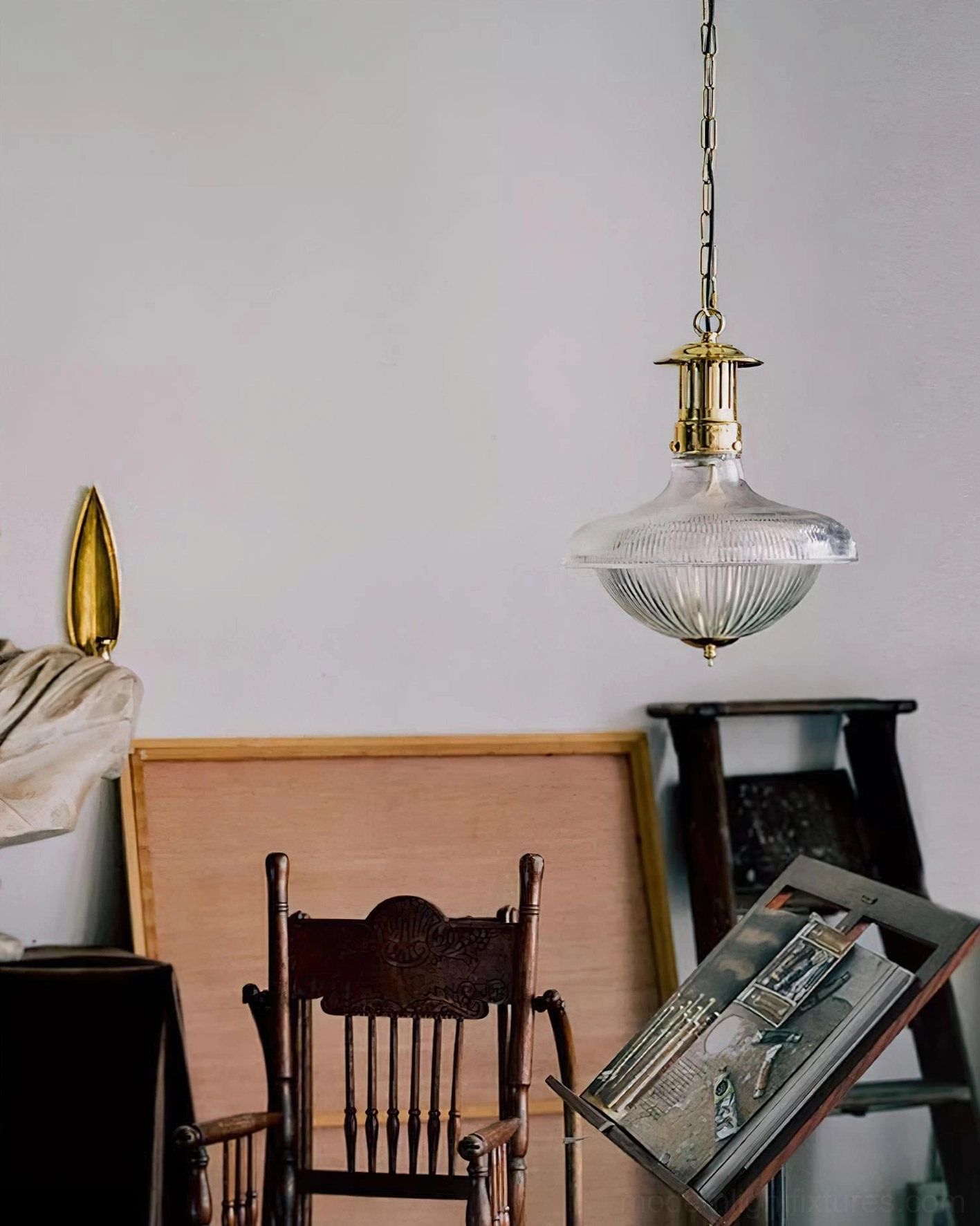 Brass and rippled glass pendant lamp hanging in minimalist interior with wooden furniture and vintage home decor