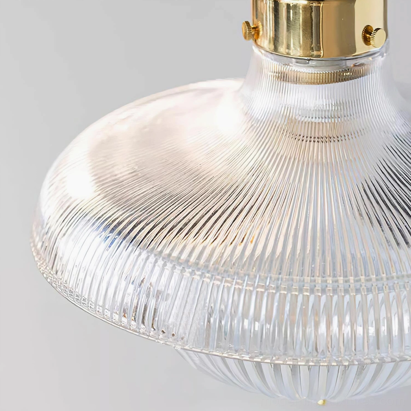 Close-up macro view of rippled glass shade texture with brass top fixture, studio white background lighting details