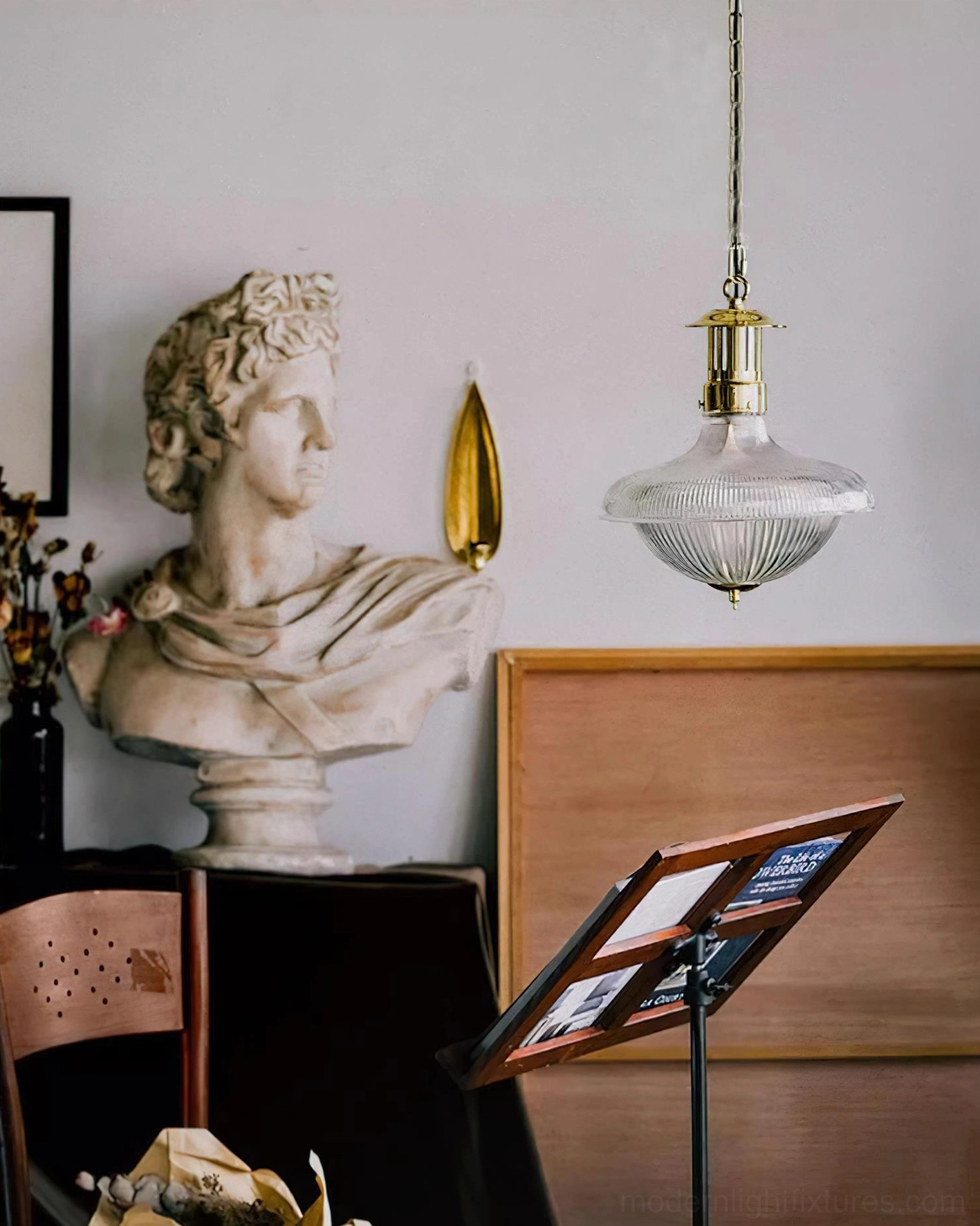 Hanging vintage brass pendant light in art studio with classical decorative elements and retro farmhouse aesthetic