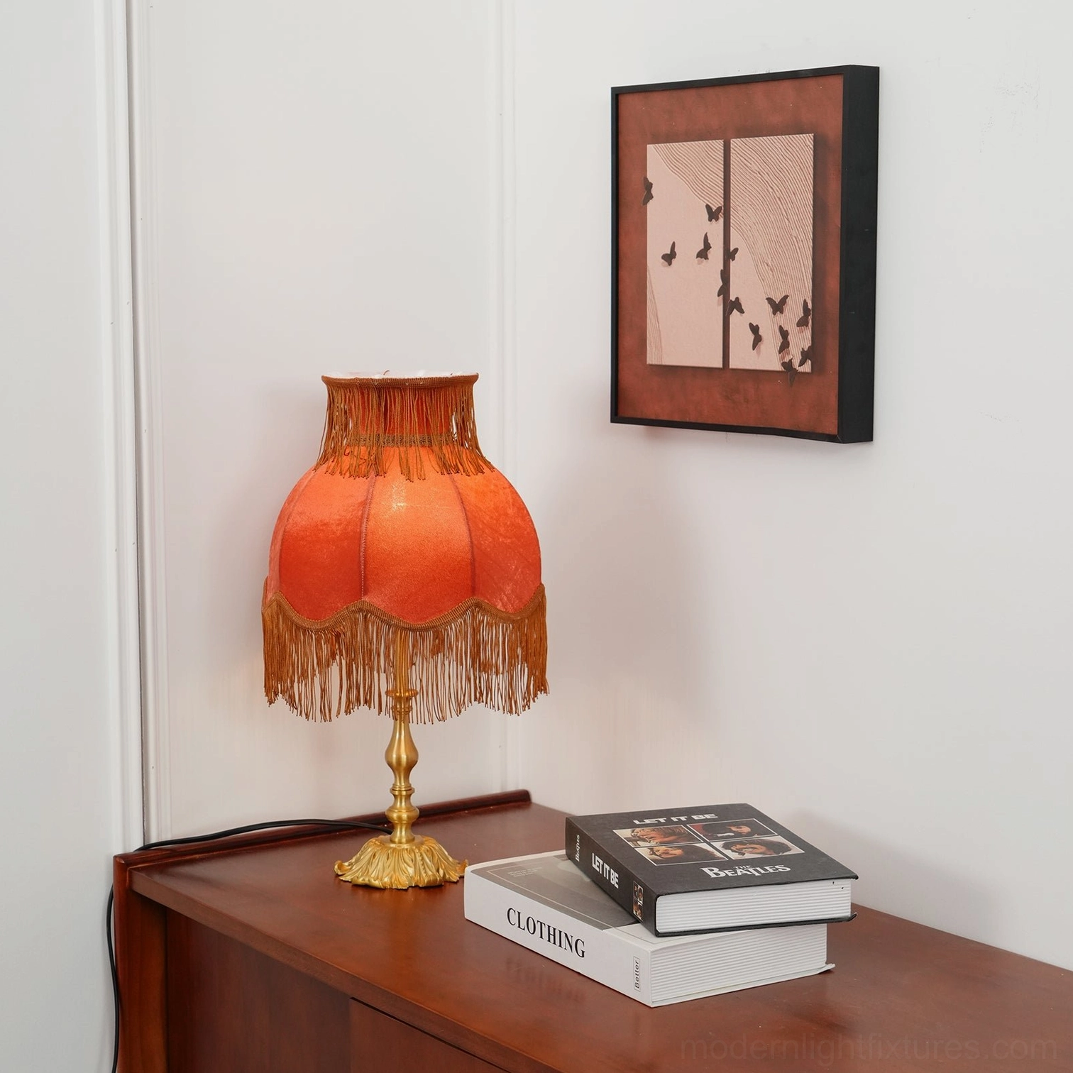 Transitional tassel table lamp with modern brass construction and traditional velvet details