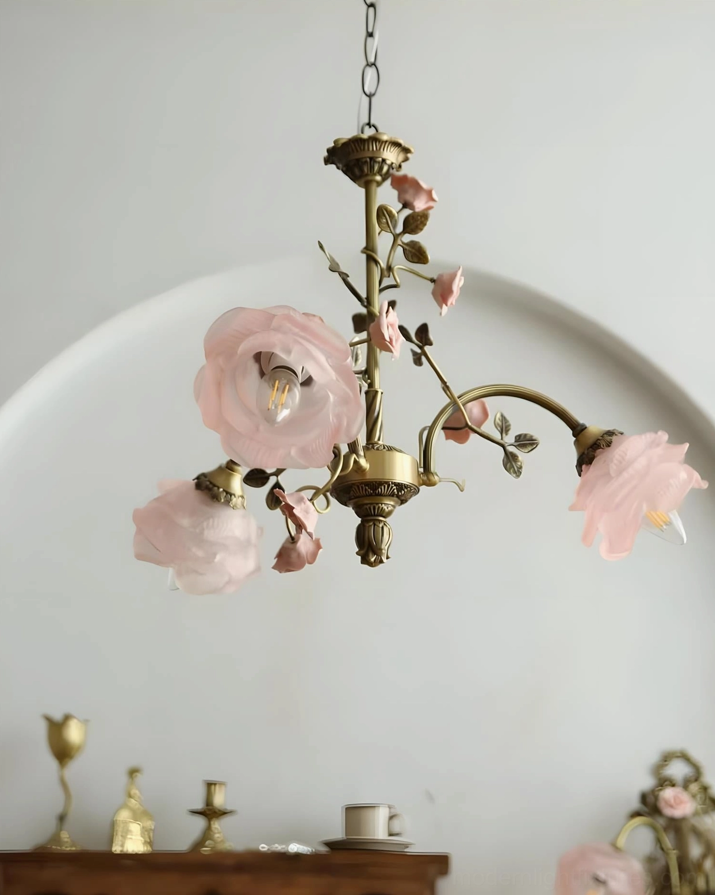 Translucent pink glass petals on romantic floral chandelier creating enchanting garden-like movement with antique frame elegance