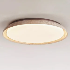 Close-up detail of travertine texture and wood canopy on modern round ceiling light fixture
