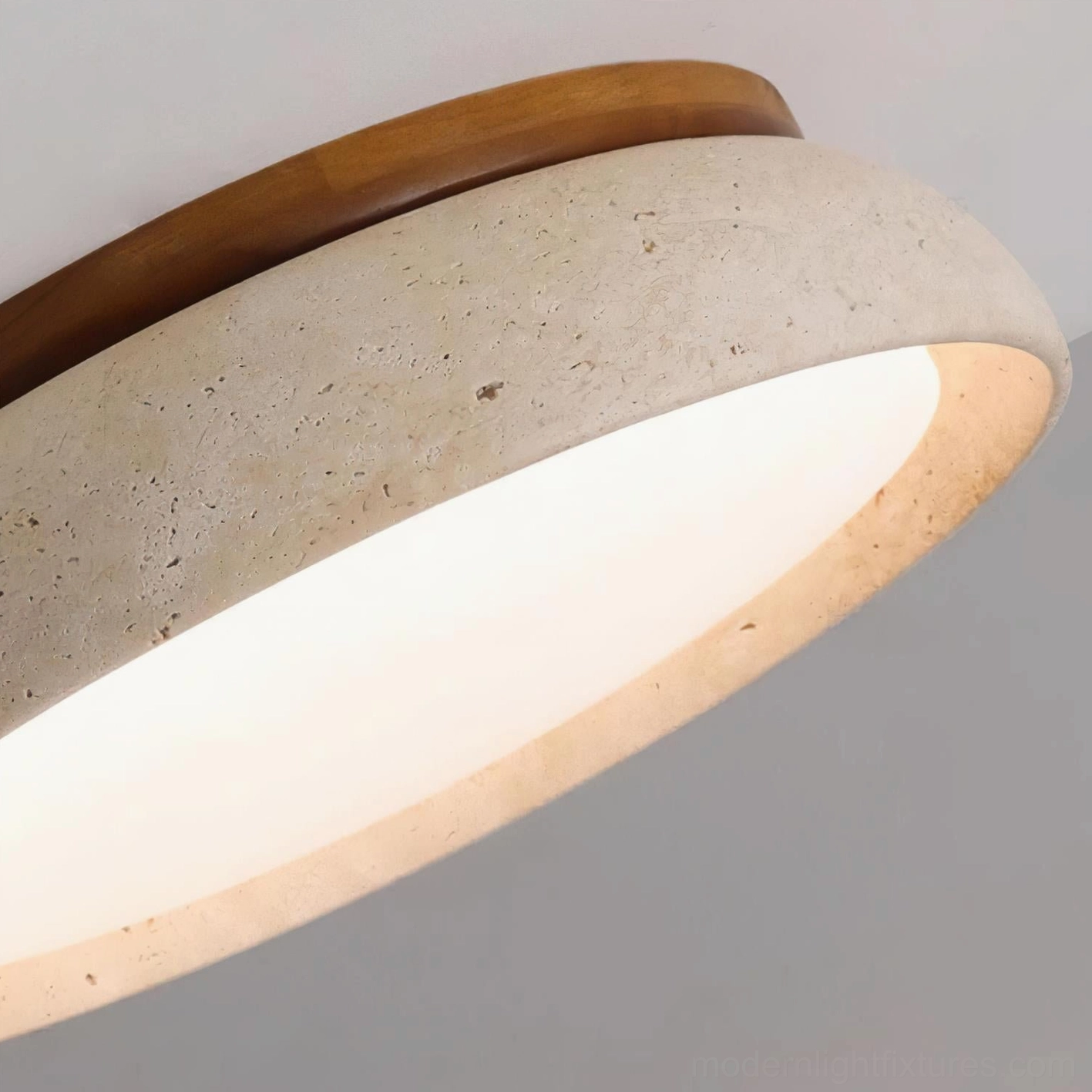 Travertine ceiling light with warm wood ring accent creating design focal point overhead