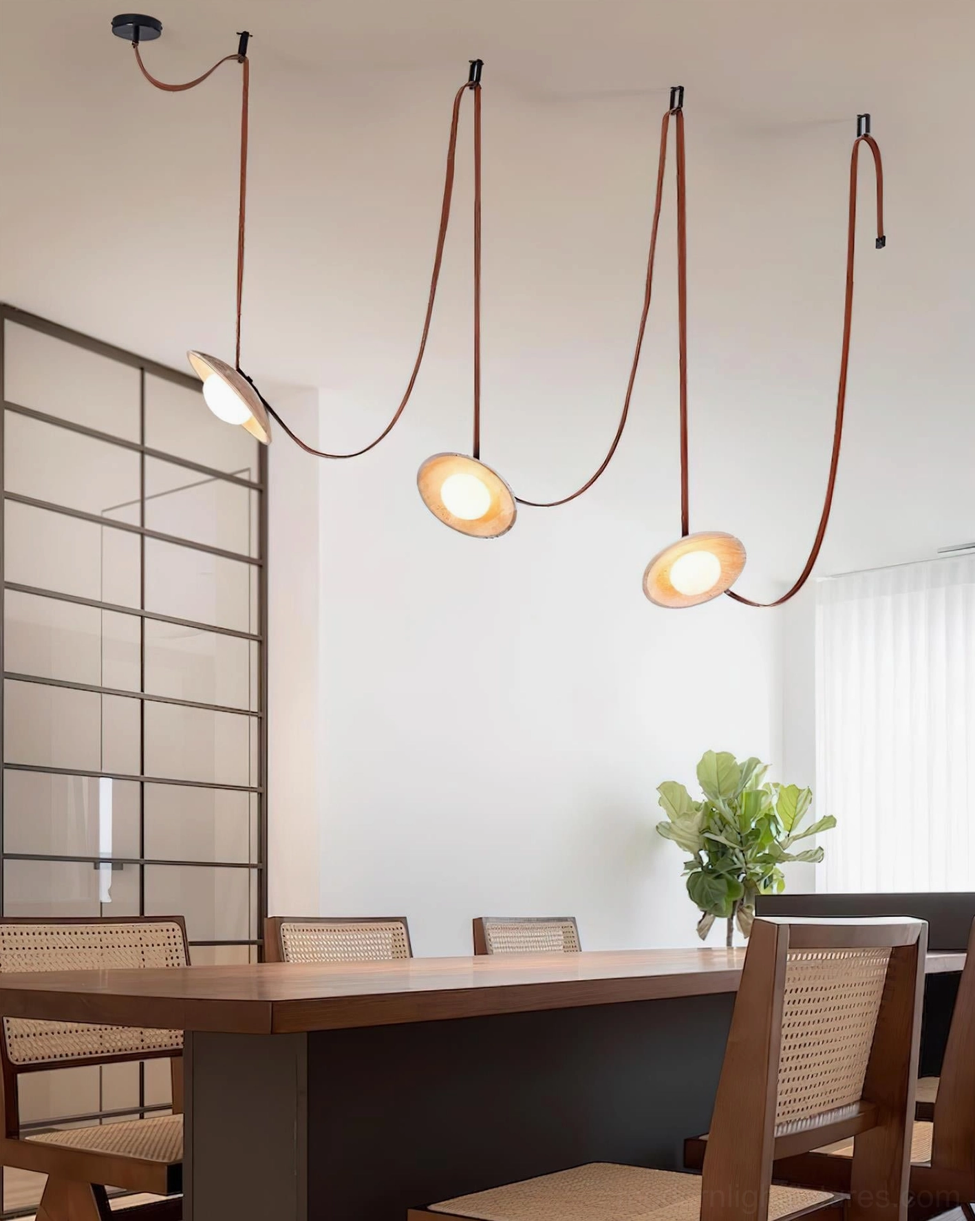 Travertine chandelier installed in modern dining room, side view showing warm illumination and leather cord details
