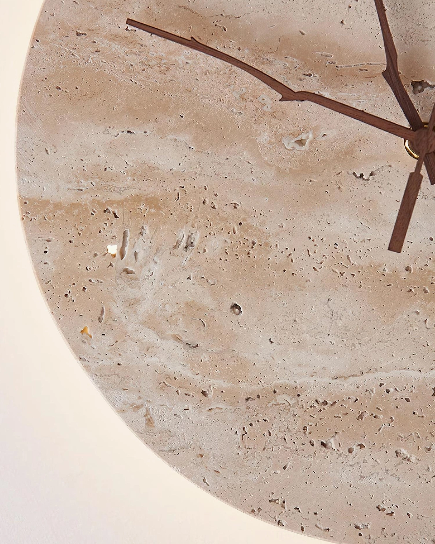 Travertine stone clock wall sconce with dark wood hands creating sculptural wall statement