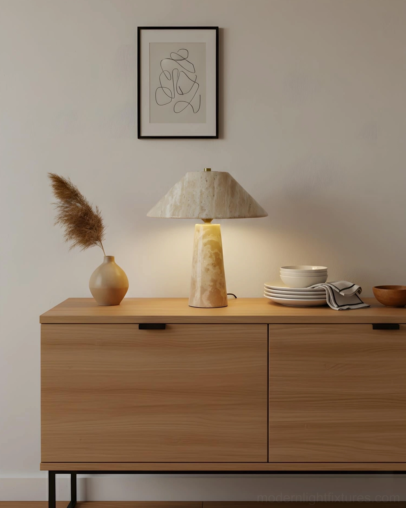 Natural stone console lamp on dining sideboard with pampas grass vase and table setting in warm modern interior