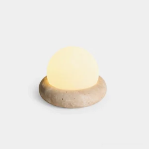 Mini Maga portable cordless LED table lamp with travertine stone base and frosted acrylic egg shade, front view with studio lighting