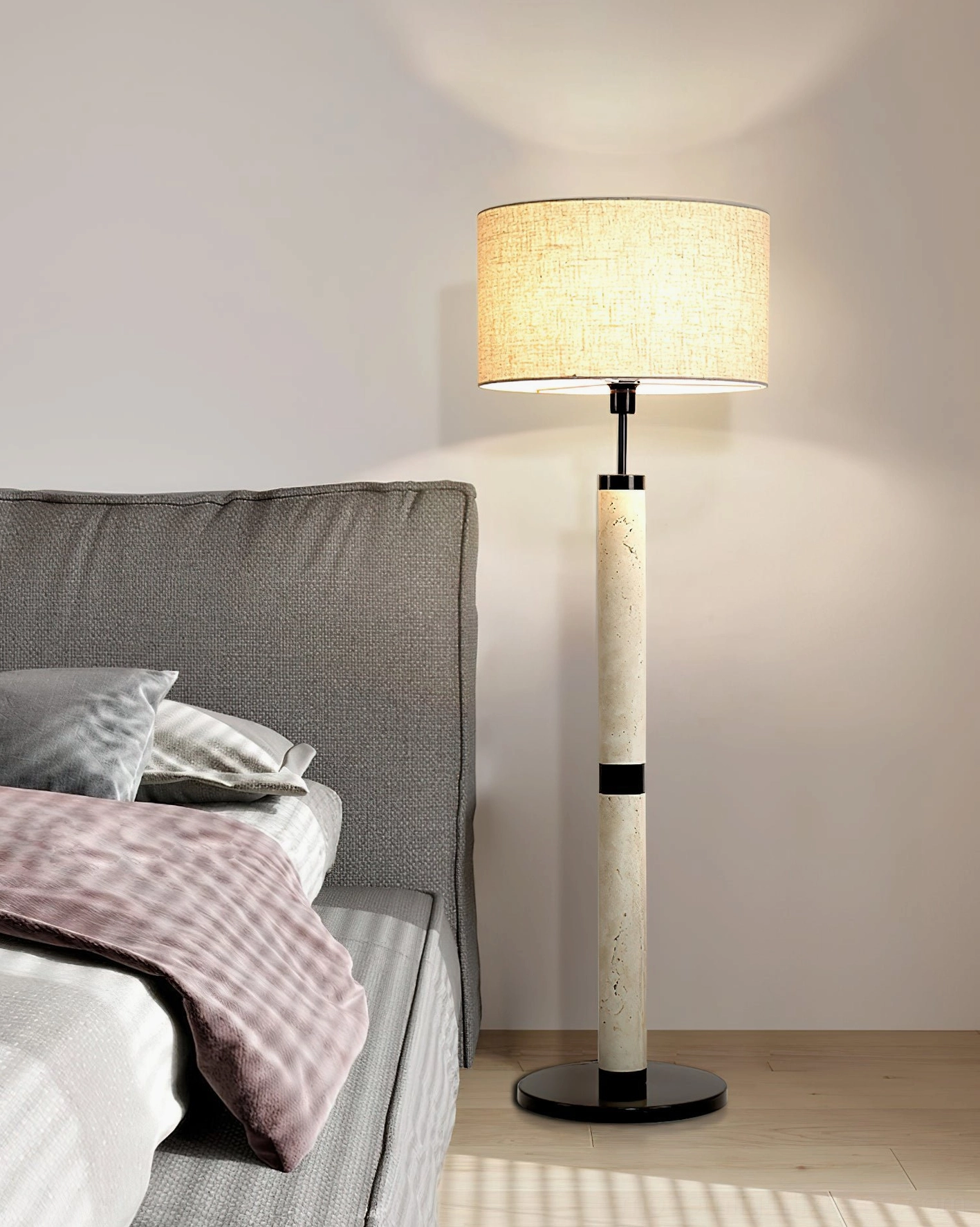 Sculptural travertine floor lamp in cozy modern bedroom - warm ambient lighting beside bed